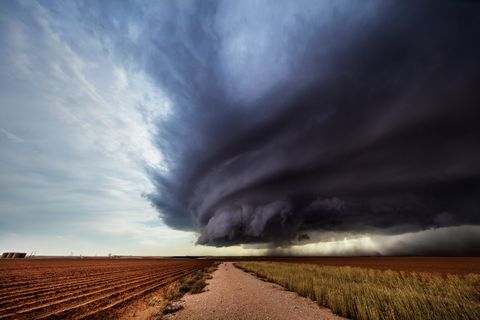 Het aambeeld van een grote supercelonweerswolk hangt dreigend boven stoffige akkers bij Lamesa Texas