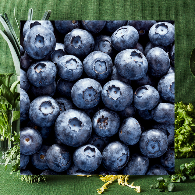 still life of leafy greens under a square filled with blueberries