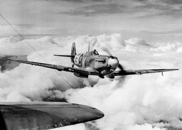 a ww 2 spitfire airplane in flight above the clouds