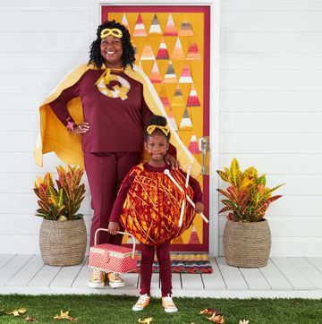 mom and daughter wearing diy superquilter and yarn girl halloween costumes on the front porch