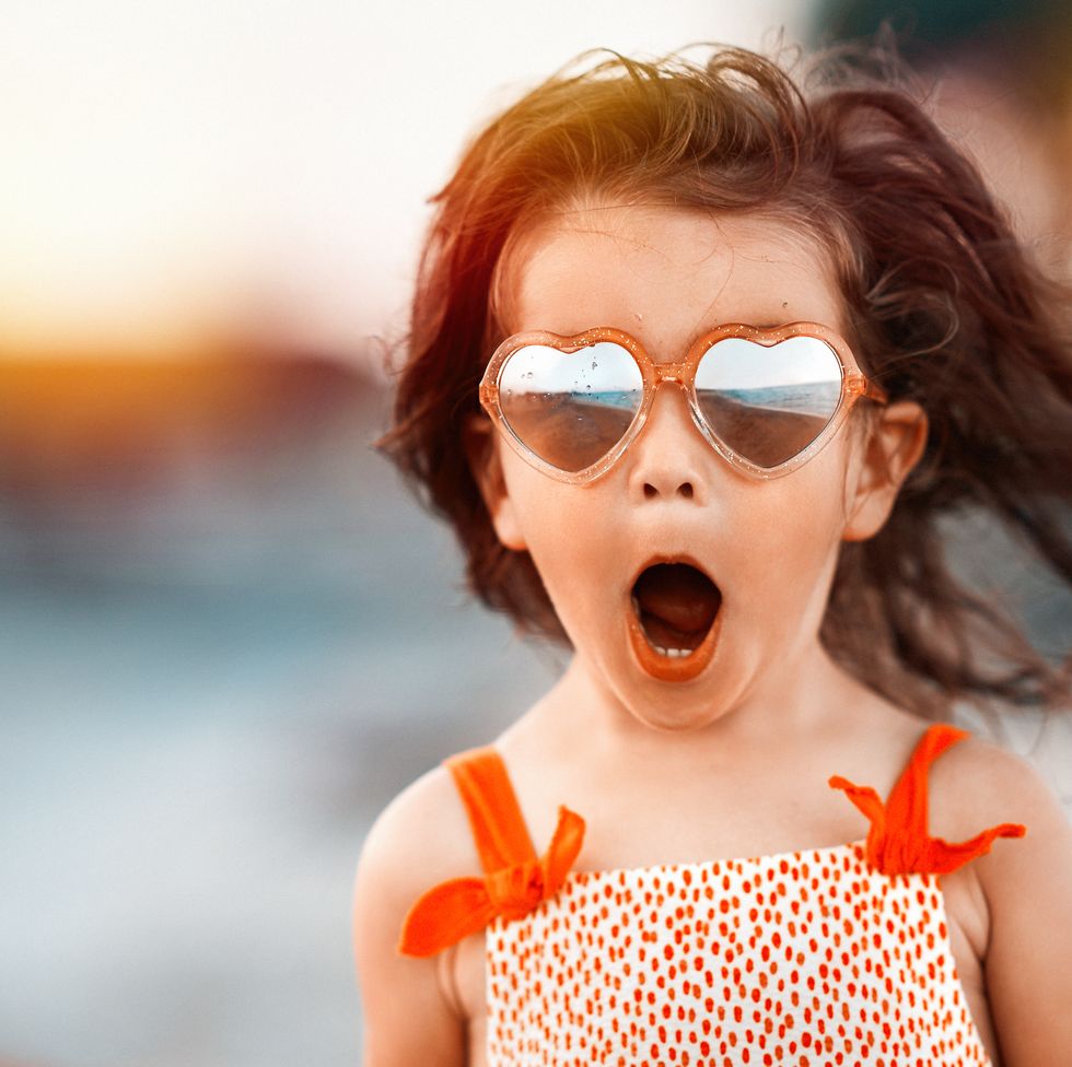 surprised baby girl wearing heart shaped glasses