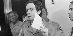 ted bundy holding a piece of paper in front of his face in court