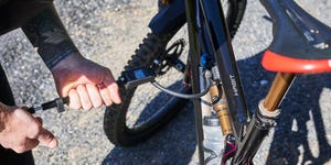 a man using a shock pump on a mountain bike