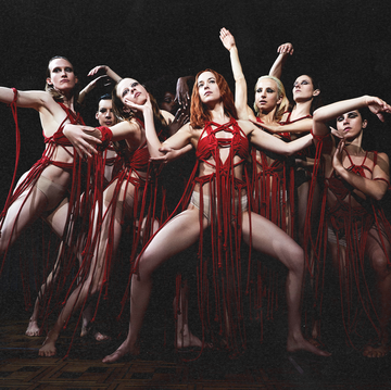 suspiria movie still featuring dakota johnson and a group of people posing in underwear and red thread