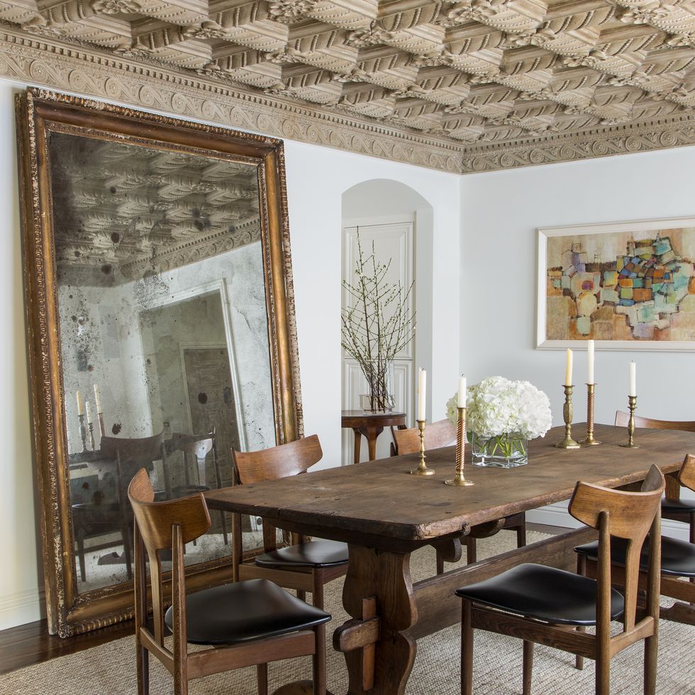 dining room with large floor mirror and wooden table