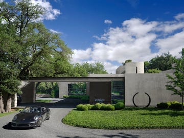 exterior of a low slung contemporary home with a black convertible in front of it