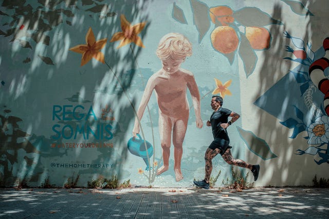 un runner corriendo enfrente de una obra de arte urbano en barcelona