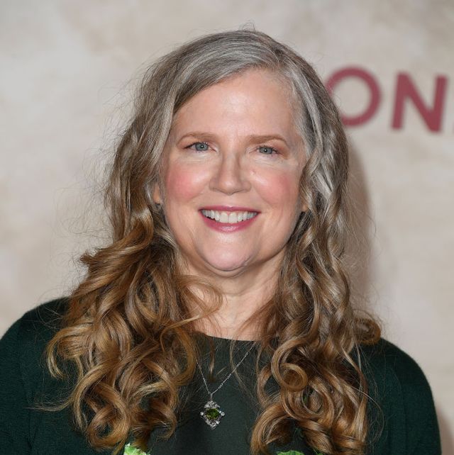 suzanne collins looking ahead and smiling for photos at a film premiere