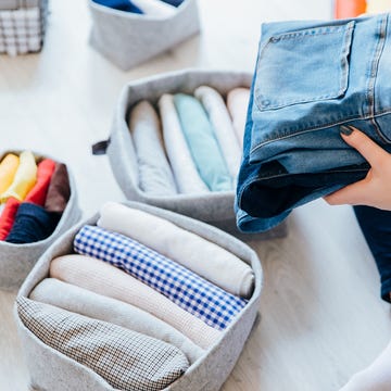 swedish death cleaning, woman's hand folding clothes into baskets