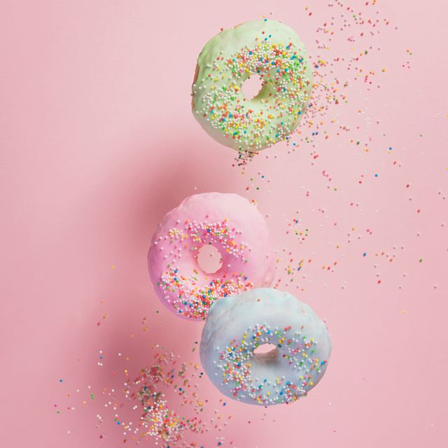sweet and colourful doughnuts with sprinkles falling or flying in motion