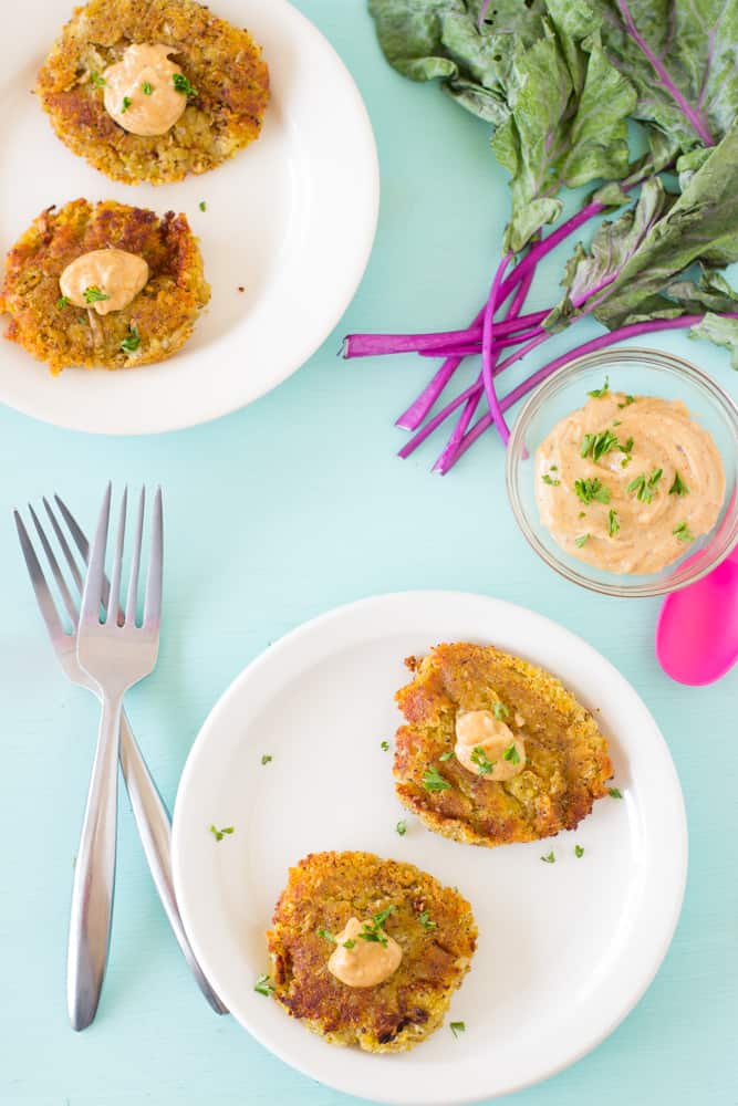 sweet potato and kohlrabi fritters with yogurt tahini sauce on a white plate