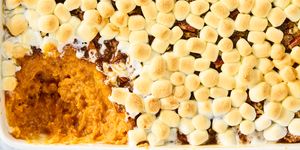 sweet potato casserole topped with toasted marshmallows in a white casserole dish