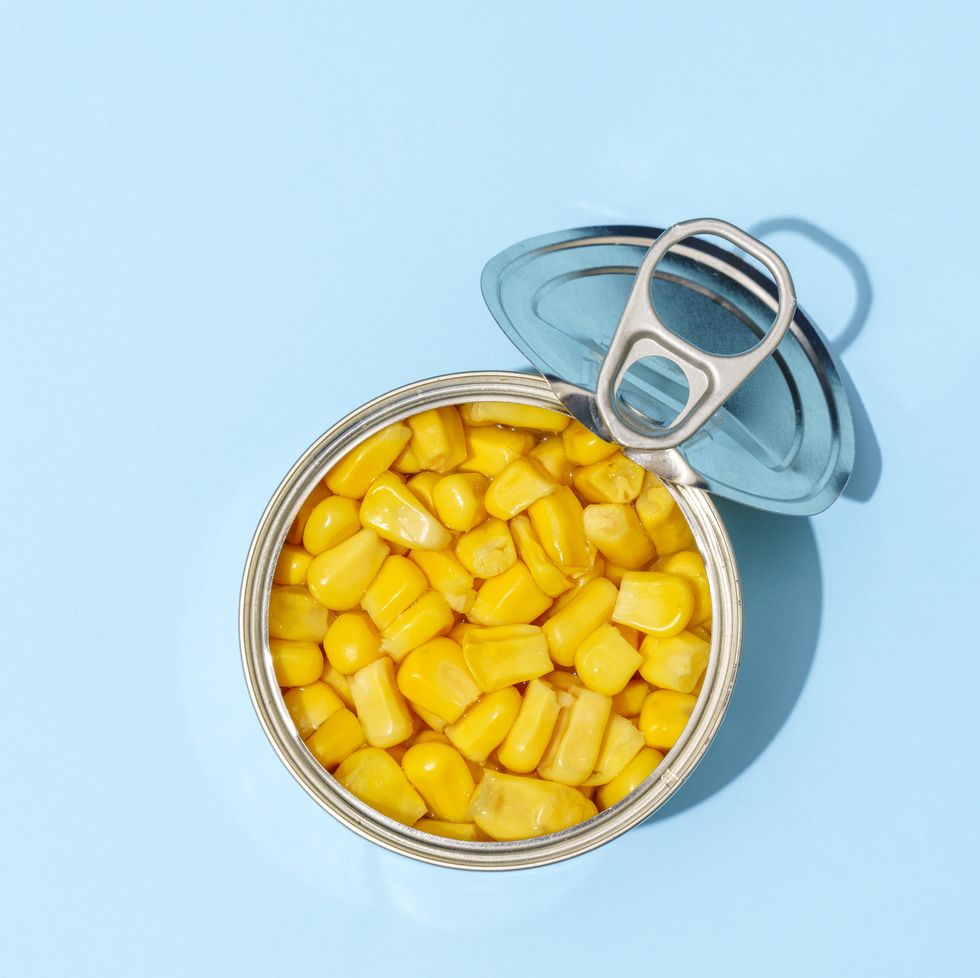 sweetcorn grains in a can on blue background