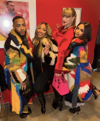 group of four individuals dressed in colorful coats posing together