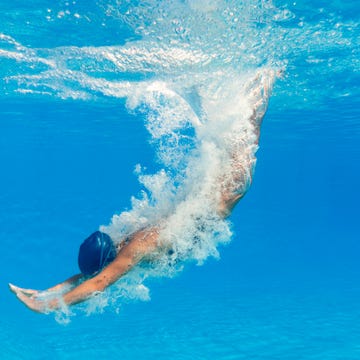 swimmer diving into a clear blue pool