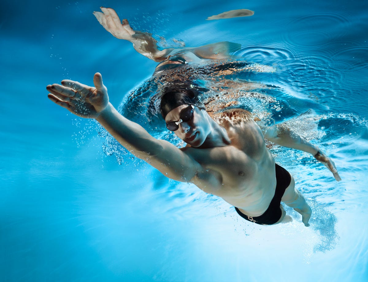 Mujer atlética con gorro de natación y gafas en piscina