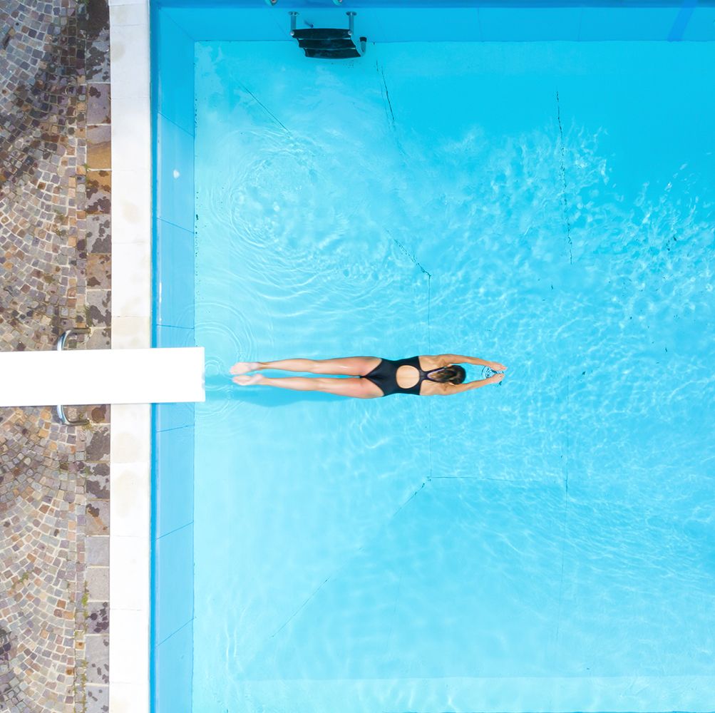 Aerial view of woman diving into swimming pool