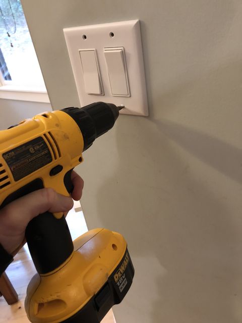 removing a light switch plate from a wall with a drill