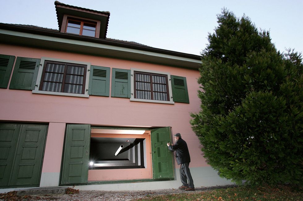 rose villa in switzerland which is pink with forest green shutters, inside there is a cannon