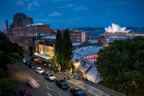 Het verlichte Opera House van Sydney is te zien vanuit de naburige wijk The Rocks