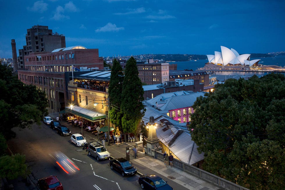 Het verlichte Opera House van Sydney is te zien vanuit de naburige wijk The Rocks