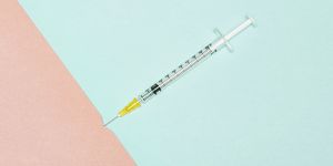 Syringe piercing skin, conceptual image