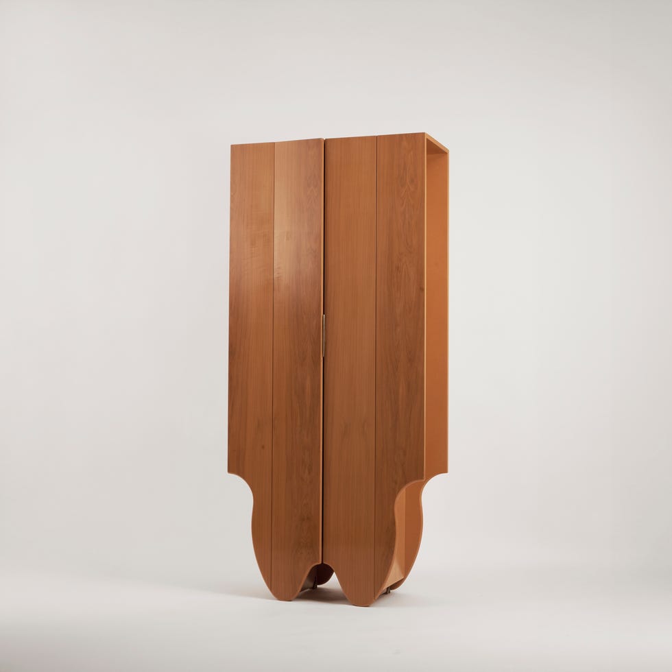 a tall wooden wardrobe with an ornate base design
