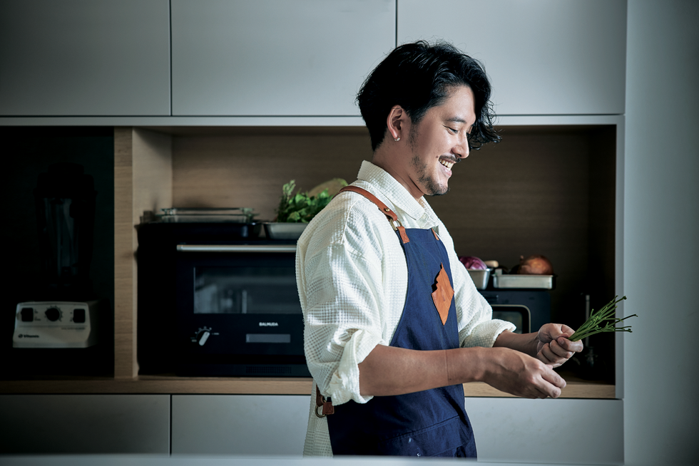 自身でデザインしたエプロンをつけた長塚さん。ビストロの元料理長というだけあって、キッチンでの所作が美しい