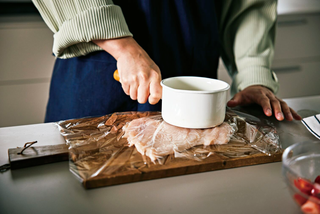 a person cutting a piece of meat