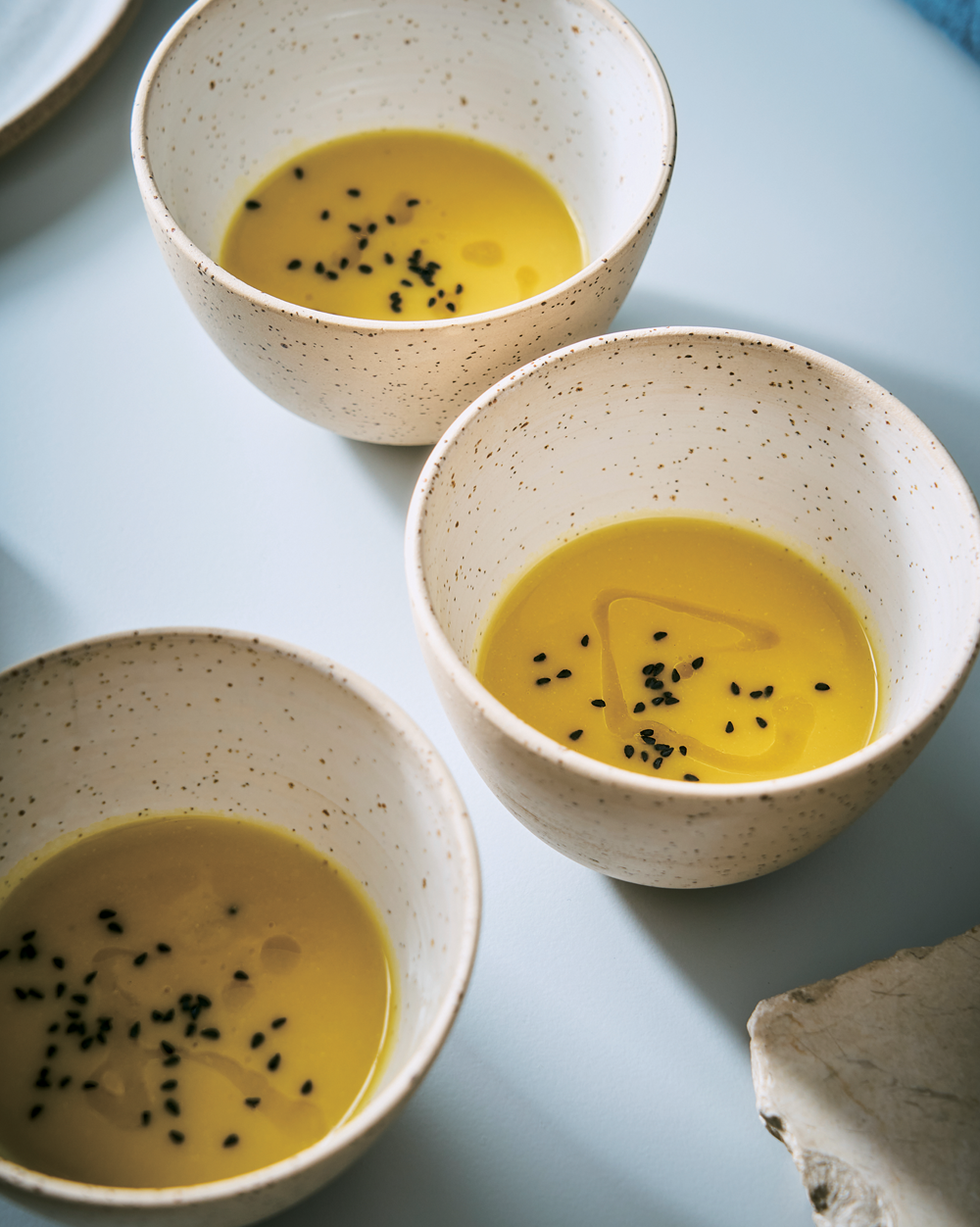 a group of small cups with yellow liquid in them