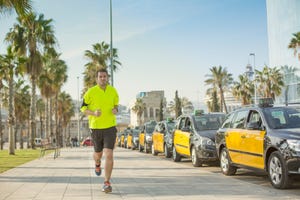 un hombre empieza a correr por la acera de una calle de barcelona