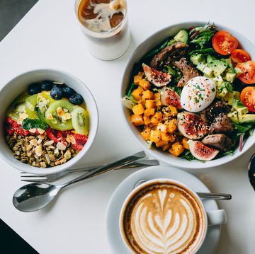 table top view of vegan chia and quinoa granola mixed fruit bowl and fresh beef cobb salad freshly served on the dining table. healthy food trend, nutritious and well balanced diet. healthy eating lifestyle concept