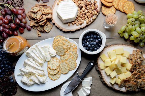 Table with cheese and fruit spread out for a party