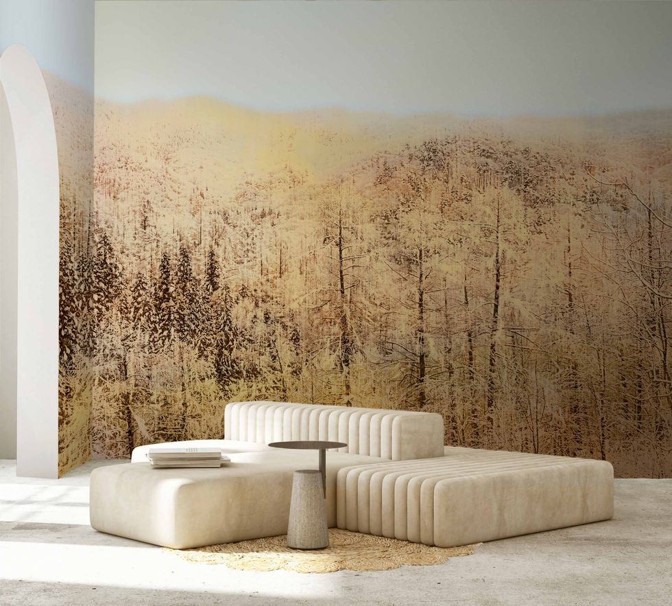 a room with wallpaper that depicts japanese forests with a modular white sofa in the center