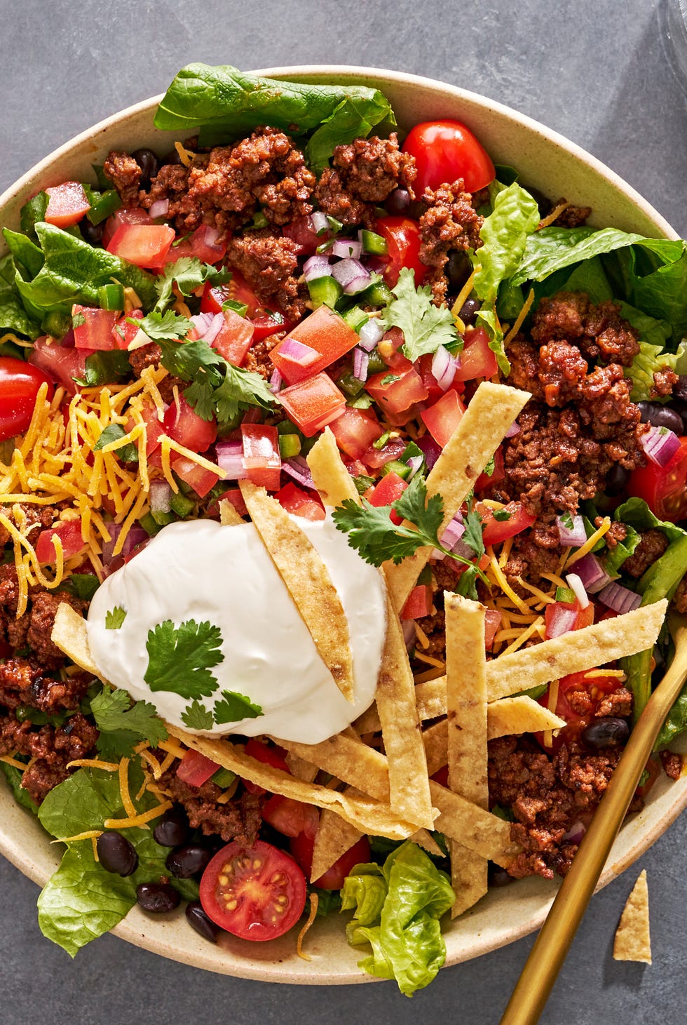Taco Salad taco salad with sour cream, tomatoes, ground beef, and tortilla strips