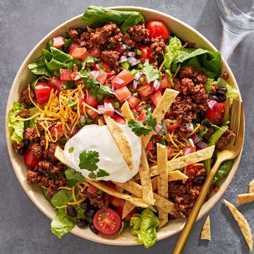 taco salad with sour cream, tomatoes, ground beef, and tortilla strips