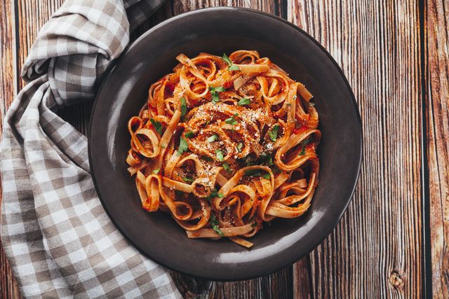 tagliatelle  with tomato sauce on wooden background