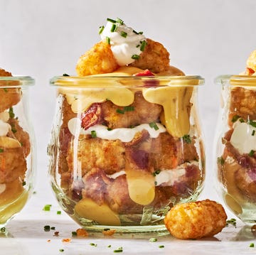 tater tots in a mason jar layered with sour cream, cheese, bacon, and chives