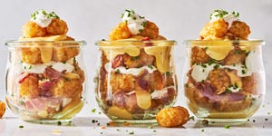 tater tots in a mason jar layered with sour cream, cheese, bacon, and chives