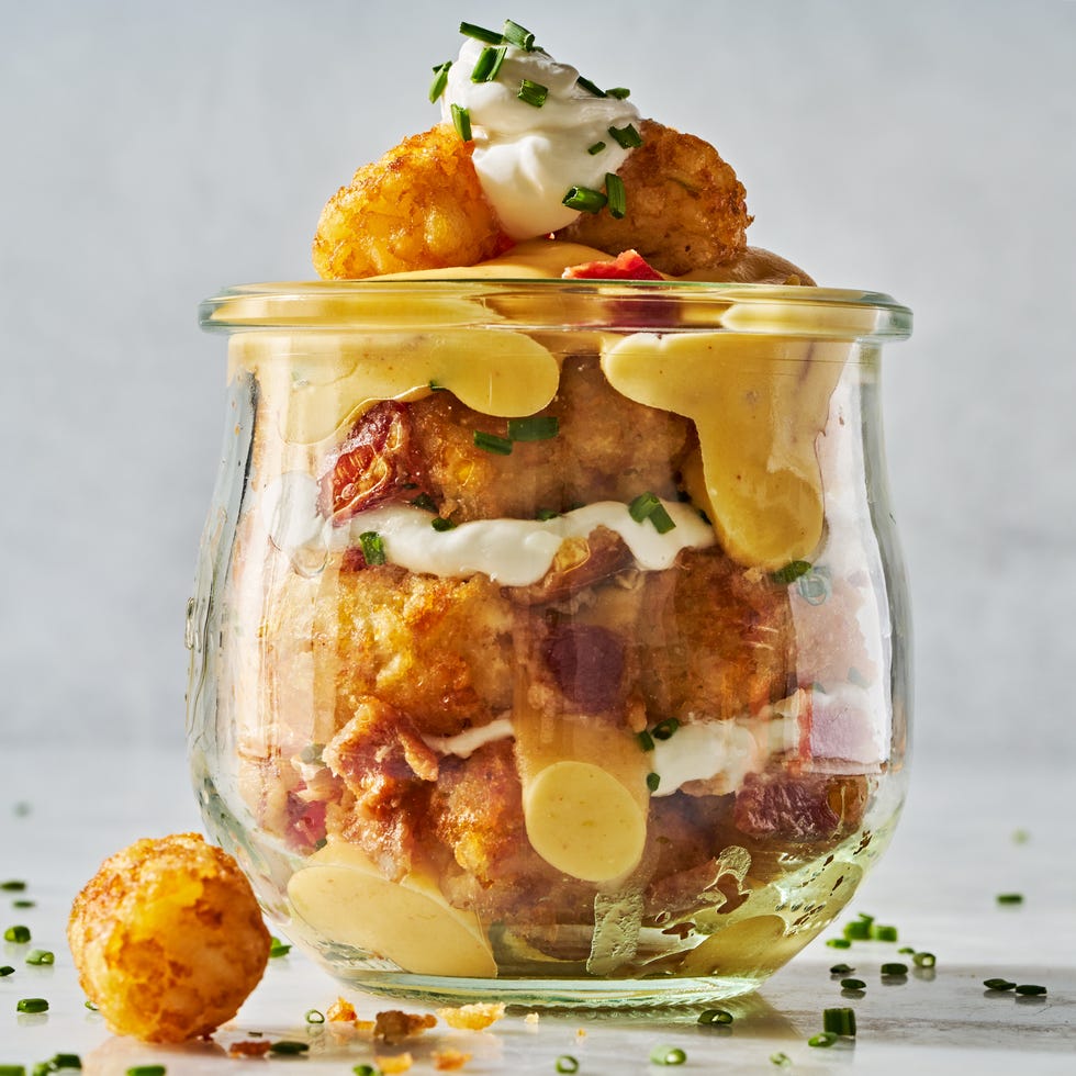 tater tots in a mason jar layered with sour cream, cheese, bacon, and chives