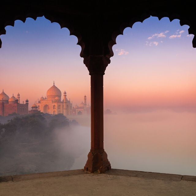 taj mahal in fog framed by arches