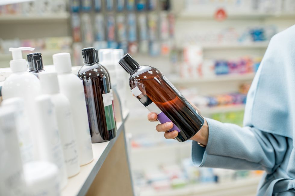 taking a bottle with cosmetics in te pharmacy