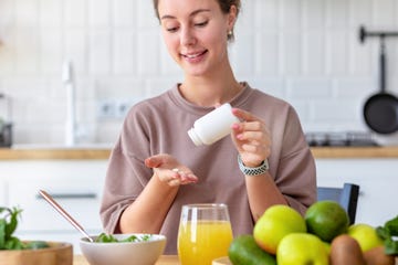 woman taking vitamin with food