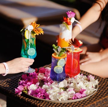 taking various cocktails from tray decorated with petals on bar table