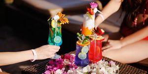 taking various cocktails from tray decorated with petals on bar table
