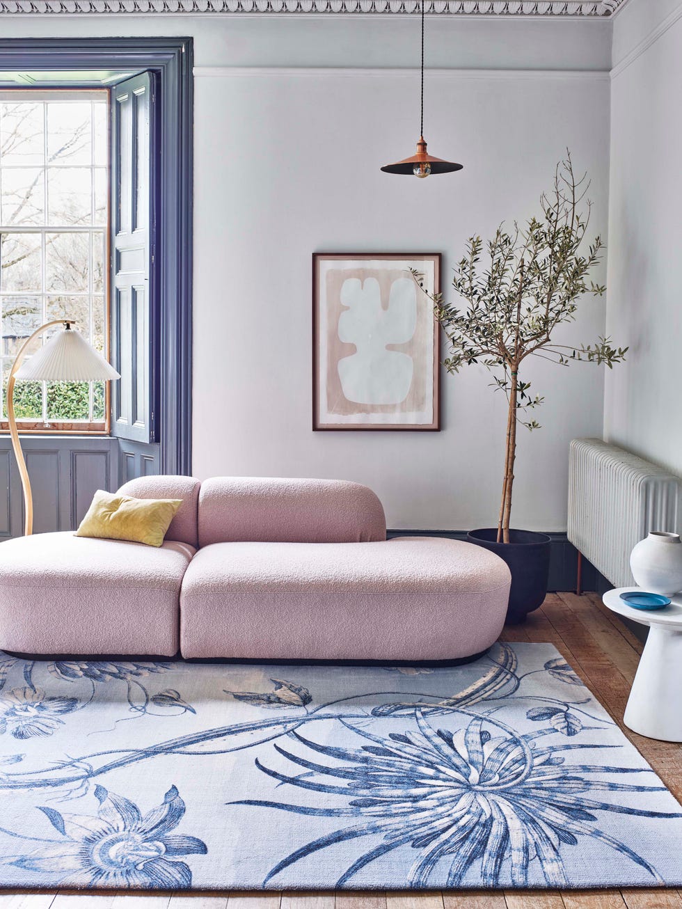 room featuring a contemporary modular pink sofa and pale blue floral rug