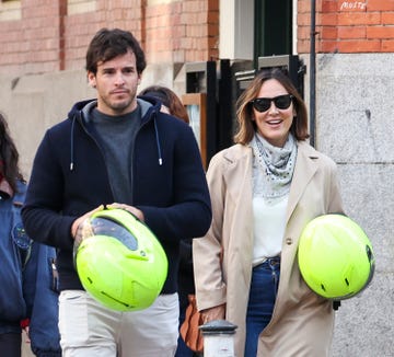 tamara falco e inigo onieva por la calle con sendos cascos de moto en la mano