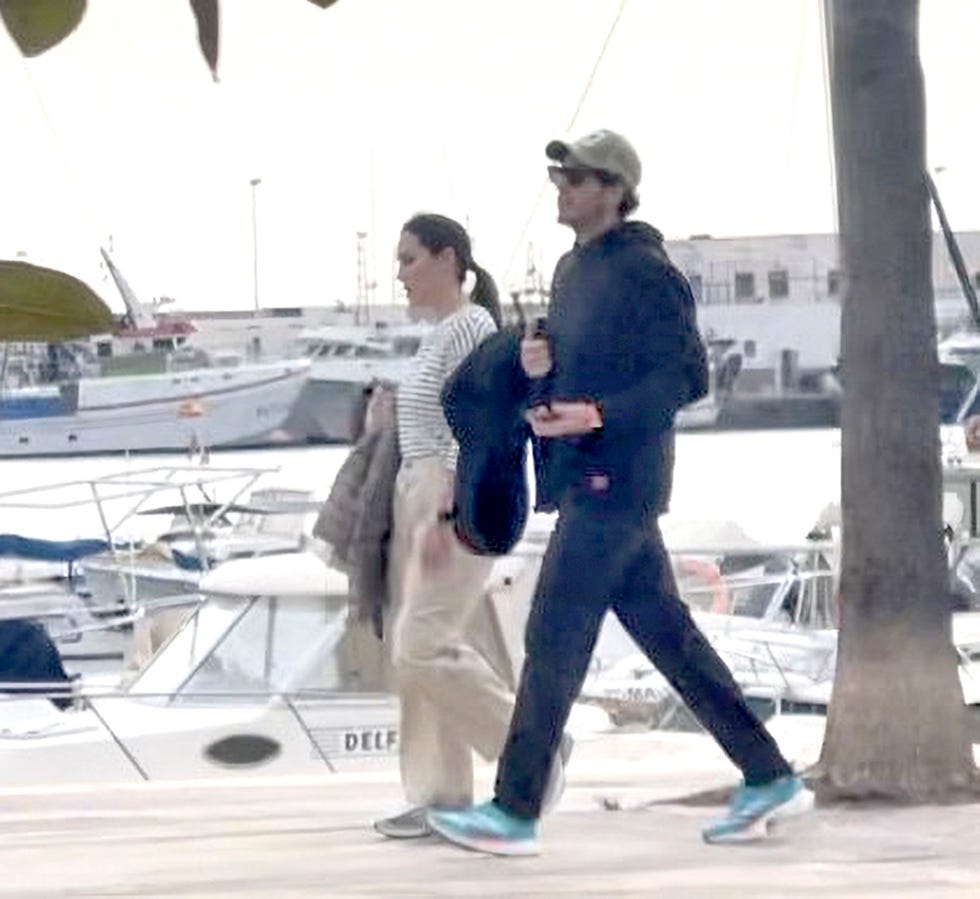 el matrimonio pasea, con ropa sport, en el puerto de altea