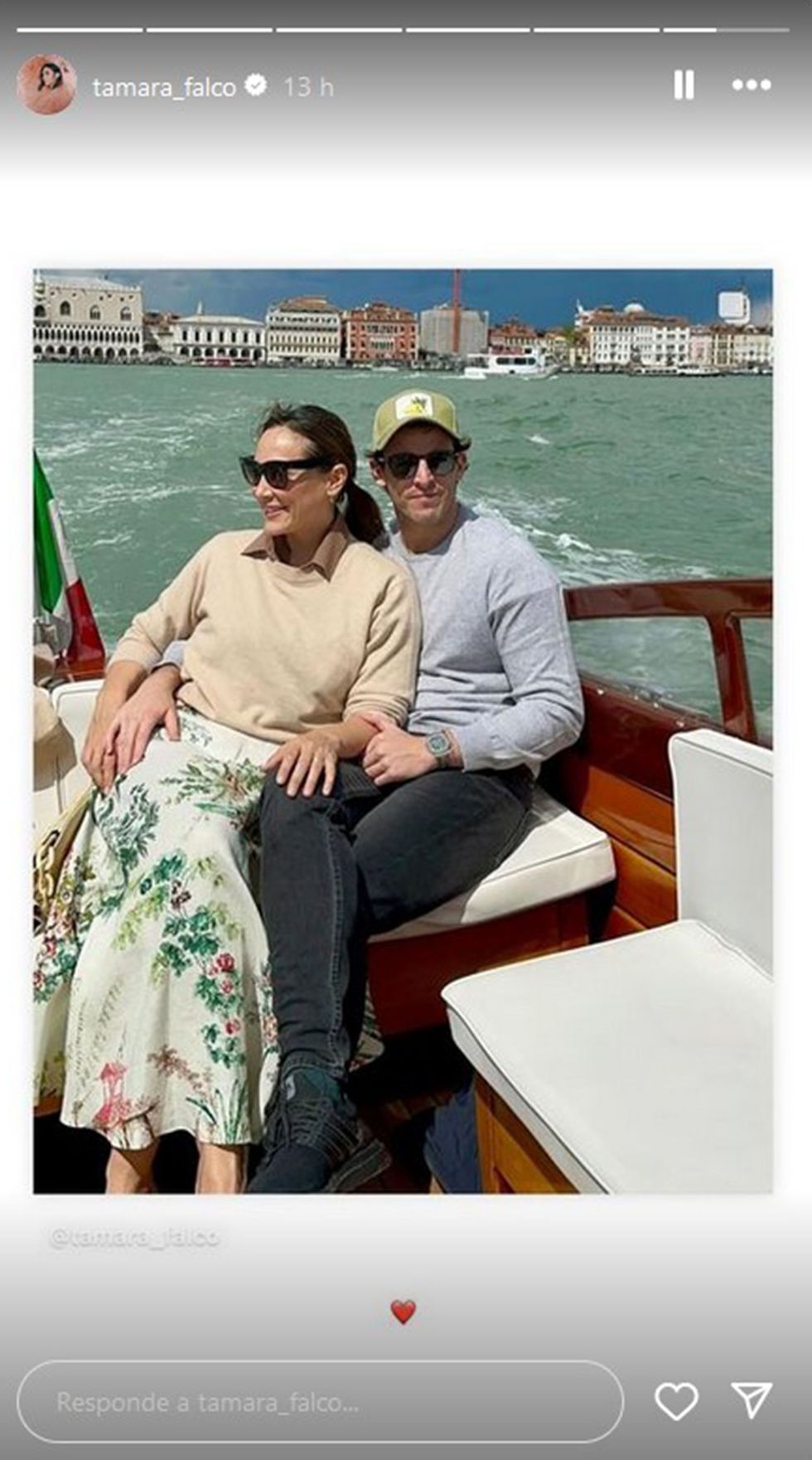 la pareja en una embarcacion recorriendo los canales de la ciudad italiana