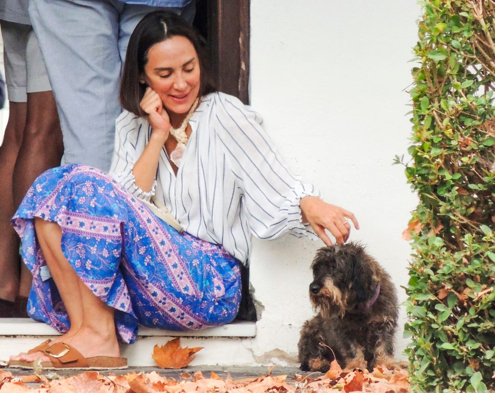 tamara falco acaricia a un perro durante una misa en sotogrande